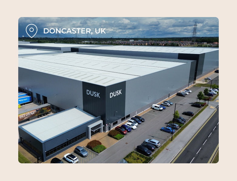Large warehouse building with 'DUSK' branding and location tag in Doncaster, UK