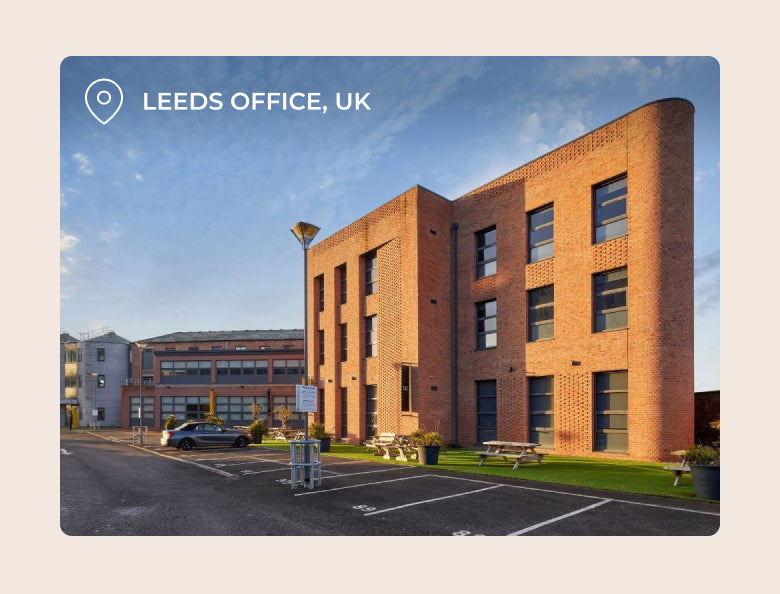 Brick office building with location tag in Leeds, UK with clear blue sky